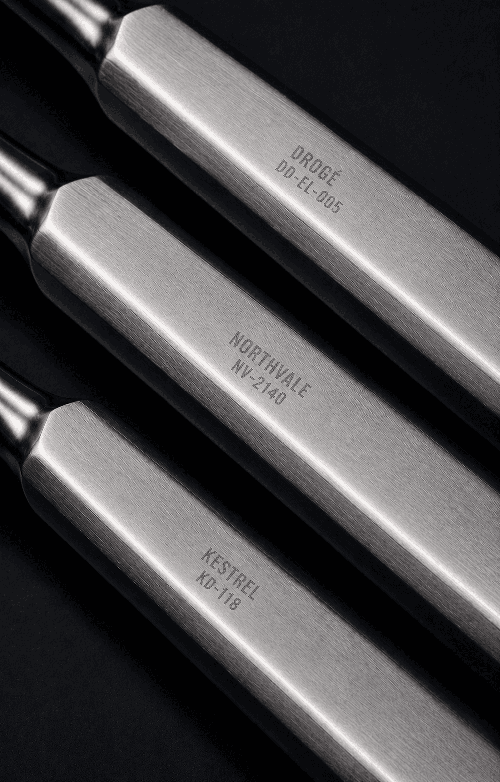 Three identical dental elevator handles, each laser-marked with a different brand name and product code